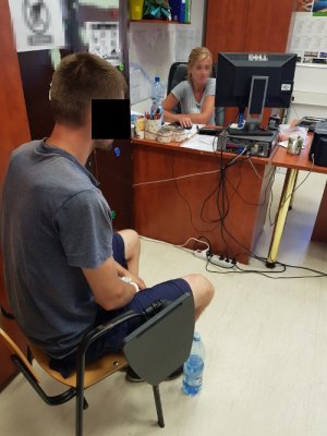 Policjantka wykonuje czynności z zatrzymanym