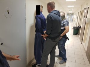 Policjanci wykonują czynności z zatrzymanym