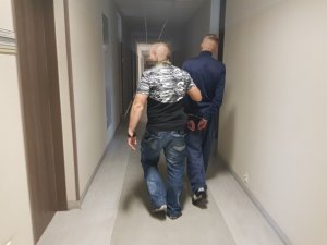 Policjanci wykonują czynności z zatrzymanym