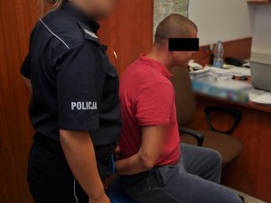 Policjanci wykonują czynności z zatrzymanym