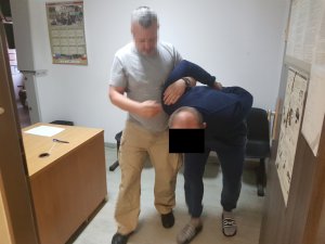 Policjanci wykonują czynności z zatrzymanym