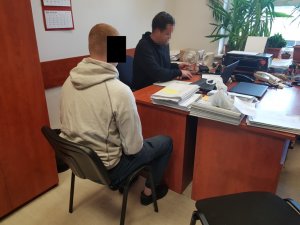 Zatrzymany mężczyzna podczas czynności z policjantem