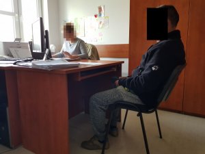 Policjantka wykonuje czynności z zatrzymanym