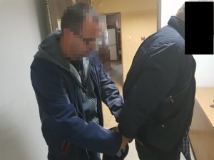 Policjant podczas czynności z zatrzymanym mężczyzną