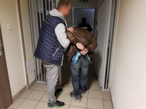 Policjant podczas czynności z zatrzymanym mężczyzną