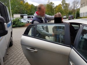 Policjant podczas czynności z zatrzymanym mężczyzną