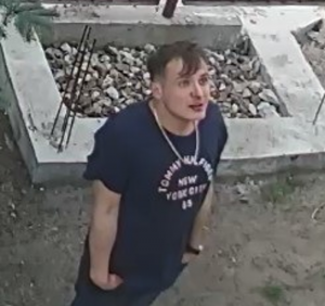 Na zdjęciu widać mężczyznę w granatowej koszulce, z napisem TOMMY HILFINGER, mężczyzna patrzy w górę i trzyma ręce w kieszeni spodni.