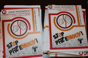 Zdjęcie przedstawia kolorowe ulotki o treści: &quot;Stop przemocy! Co ROBIMY, CO ZROBIMY dla BEZPIECZEŃSTWA w szkole, w domu, w dzielnicy? Nie jestem obojętny, widzę i działam&quot;. Pod spodem widnieje napis &quot;STOP PRZEMOCY&quot;