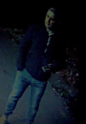 na zdjęciu widać mężczyznę w jeansowych spodniach, ciemnej kurtce i ciemnej czapce na głowie