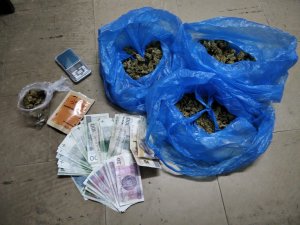 Na zdjęciu widać zabezpieczone narkotyki w workach oraz pieniądze