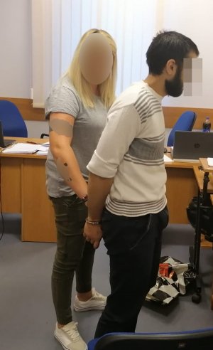Na zdjęciu widać policjantkę w ubiorze cywilnym oraz zatrzymanego mężczyznę w kajdankach