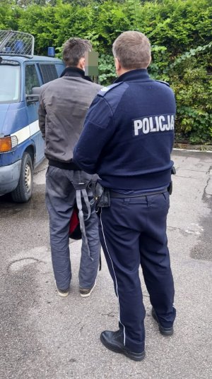 Policjant w mundurze z zatrzymanym mężczyzną