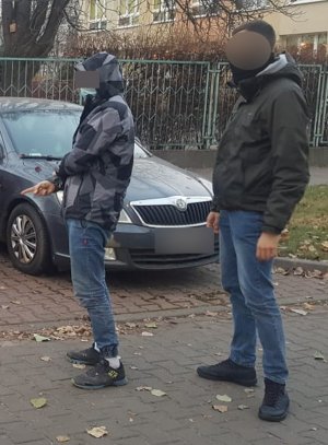 na zdjęciu widać zatrzymanego mężczyznę wskazującego policjantowi miejsce dokonania przestępstwa