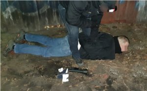 na zdjęciu widać policjanta z zatrzymanym mężczyzną leżącym na ziemi