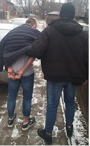 na zdjęciu widać policjanta z zatrzymanym mężczyzną