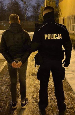 na zdjęciu widać policjanta z zatrzymanym mężczyzną