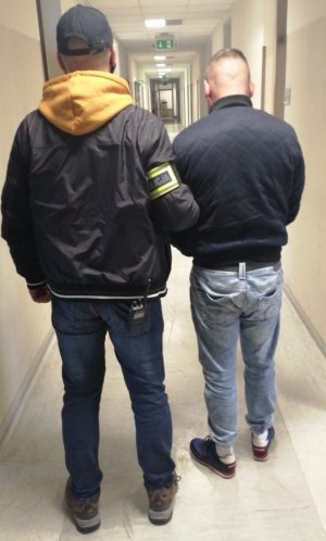 Policjant z zatrzymanym mężczyzną