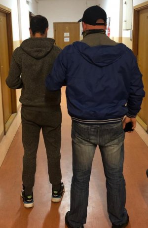 Policjant z zatrzymanym mężczyzną