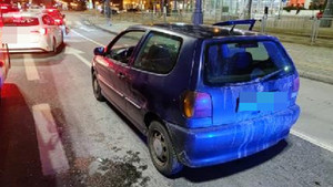 Zdjęcie przedstawia niebieski pojazd m-ki Volkswagen stojący na pasie ruchu.