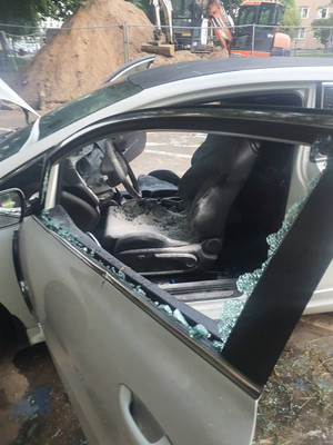 Zdjęcie przedstawia spalone wnętrze srebrnego samochodu. Szyba od przednich lewych drzwi od strony kierowcy jest wybita.