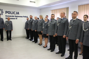 Zdjęcie przedstawia funkcjonariuszy stojących w jednym rzędzie na sali w uroczystych mundurach.