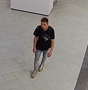 Zdjęcie przedstawia mężczyznę w wieku około 25 lat, szczupłej budowy ciała. Ubrany jest w czarną koszulkę, niebieskie spodnie i sportowe buty.