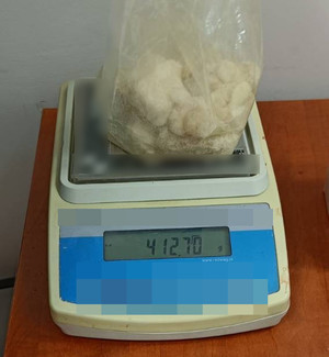 Zdjęcie przedstawia leżącą na wadze foliową torebkę wewnątrz której znajduje się zbrylona biała substancja.