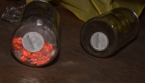 Zdjęcie przedstawia dwa okrągłe przezroczyste pojemniki. Na spodzie jednego z nich widać pomarańczowe tabletki.