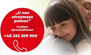 Zdjęcie przedstawia dziewczynkę o ciemnych włosach wtuloną w ramię kobiety. Przed nią widać czerwone koło z informacją napisaną białymi literami.