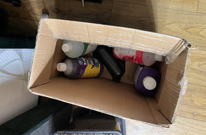 Zdjęcie przedstawia kartonowe pudełko a w nim butelki z różnymi etykietami.