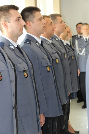 Zdjęcie przedstawia policjantów w granatowych mundurach służbowych stojących obok siebie w jednym rzędzie.