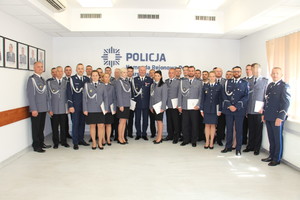 Zdjęcie przedstawia policjantów w granatowych mundurach, którzy uśmiechają się do zdjęcia.