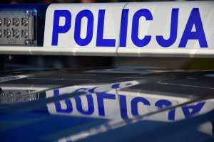 Zdjęcie przedstawia lampę radiowozu z niebieskim napisem POLICJA.