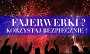 Zdjęcie przedstawia fajerwerki wystrzelone w ciemne niebo nad stojącymi ciemnymi sylwetkami osób. W tle widać napis: &quot;Fajerwerki? Korzystaj bezpiecznie!&quot;.