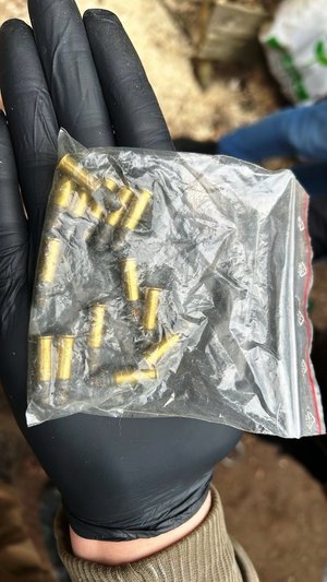 Zdjęcie przedstawia amunicję zapakowaną w przezroczystą torebkę leżącą na dłoni ubranej w czarną ochronną rękawiczkę.