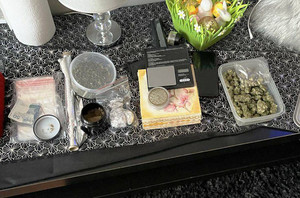 Zdjęcie przedstawia susz roślinny i inne substancje rozłożone do pojemników leżących na niskim stole.
