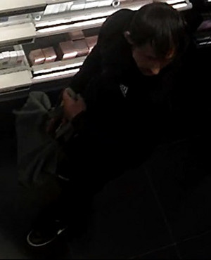 Zdjęcie przedstawia fragment sylwetki mężczyzny ubranego na ciemno, który w dłoniach trzyma szarą torbę.