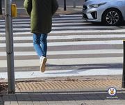 Zdjęcie przedstawia sylwetkę osoby przechodzącej przez przejście dla pieszych.