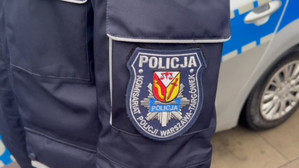 Zdjęcie przedstawia naszywkę z napisem Komisariat Policji Warszawa Targówek umieszczonej na rękawie kurtki policyjnej.