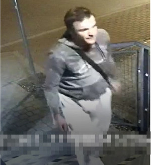 Zdjęcie jest w kolorze szarym. Przestawia mężczyznę o ciemnych włosach.