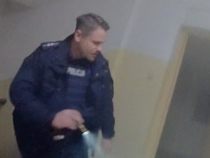 Policjanci wyprowadzili kobietę z płonącego mieszkania