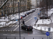 Zdjęcie przedstawia skrzyżowanie ulic z ciemnym pojazdem, który znajduje się na jezdni.