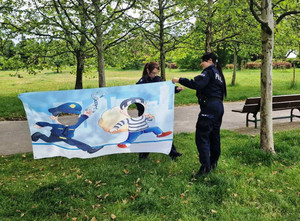 Zdjęcie przedstawia dwie policjantki trzymające kolorowy baner.