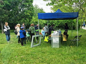 Zdjęcie przedstawia stoisko policyjne przy którym stoi duża grupa osób.