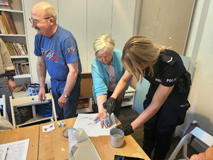 Policjantka prowadzi warsztaty kryminalistyczne dla seniorów.