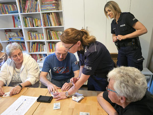 Policjantki prowadzą warsztaty kryminalistyczne dla seniorów.