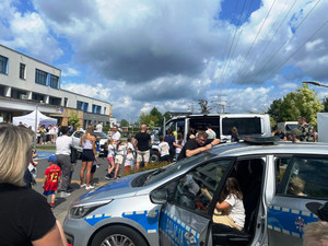 uczestnicy pikniku oglądają radiowóz.