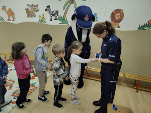 policjantka wykonuje stempel dziecku.