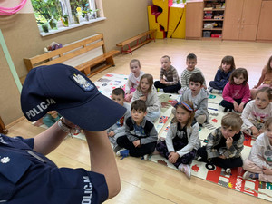 policjantka prezentuje dzieciom policyjną czapkę.