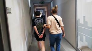 Policjant prowadzi zatrzymanego.